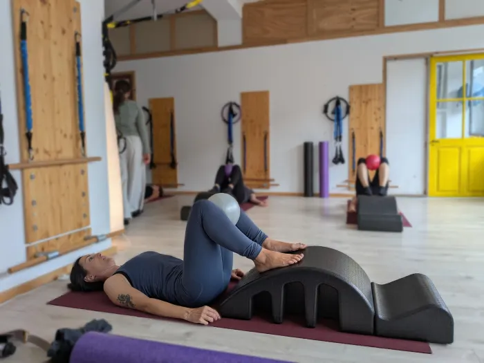 A client on the mat with a Pilates arc